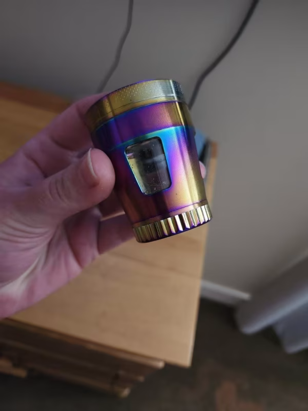 grinder-grande-4-capas-translucido-morado-dorado-trituradora-metalica-50mm-420mx-4 Grinder metálico morado-dorado de 50 mm sostenido en mano para mostrar tamaño