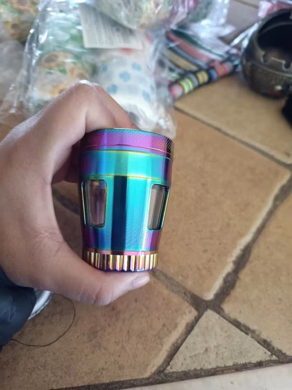 grinder-grande-4-capas-translucido-morado-dorado-trituradora-metalica-50mm-420mx-5 Grinder metálico morado-dorado de 50 mm sostenido en mano para mostrar tamaño